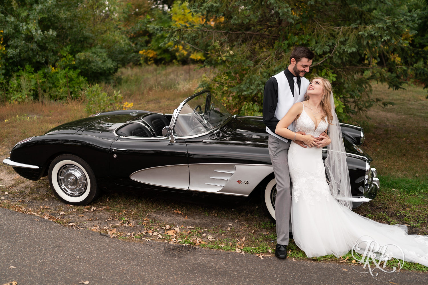 Bride and groom kiss in front of a vintage Corvette at Bunker Hills Event Center in Coon Rapids, Minnesota.