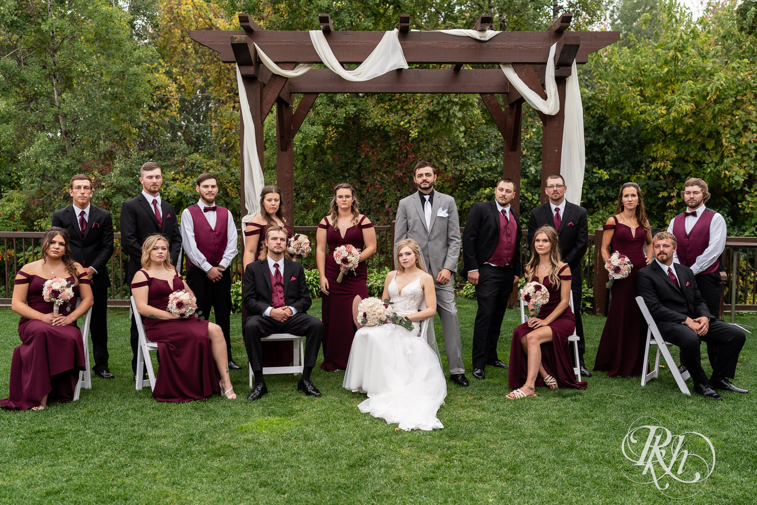 Bride and groom smile with wedding party at Bunker Hills Event Center in Coon Rapids, Minnesota.