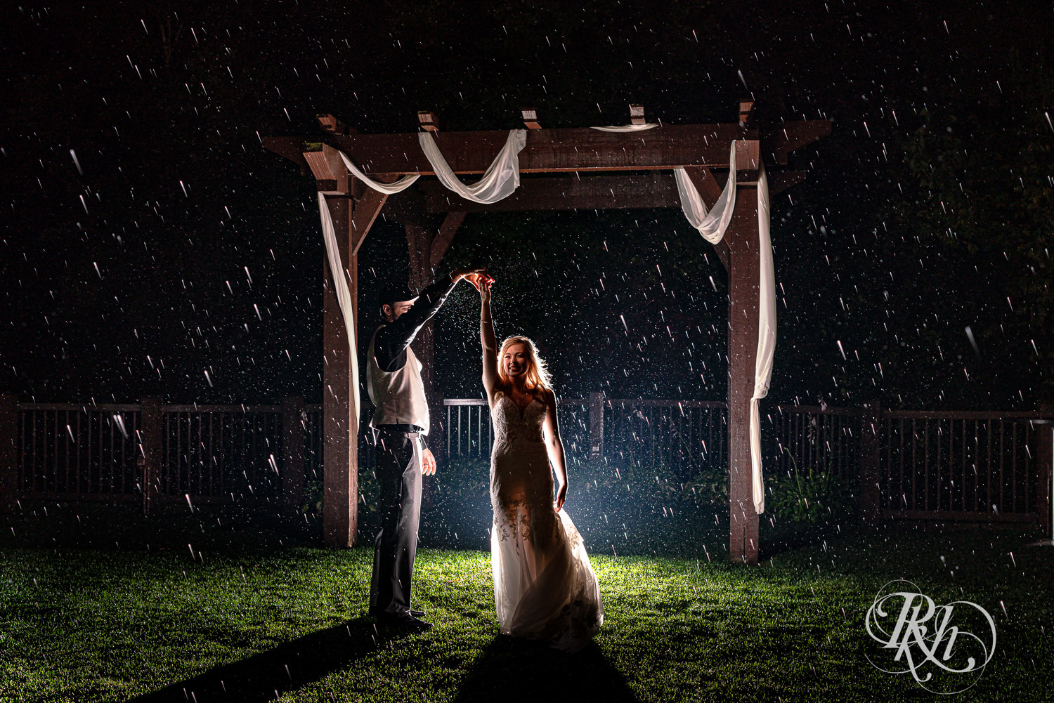 Bride and groom dance in the rain on wedding day at Bunker Hills Event Center in Coon Rapids, Minnesota.