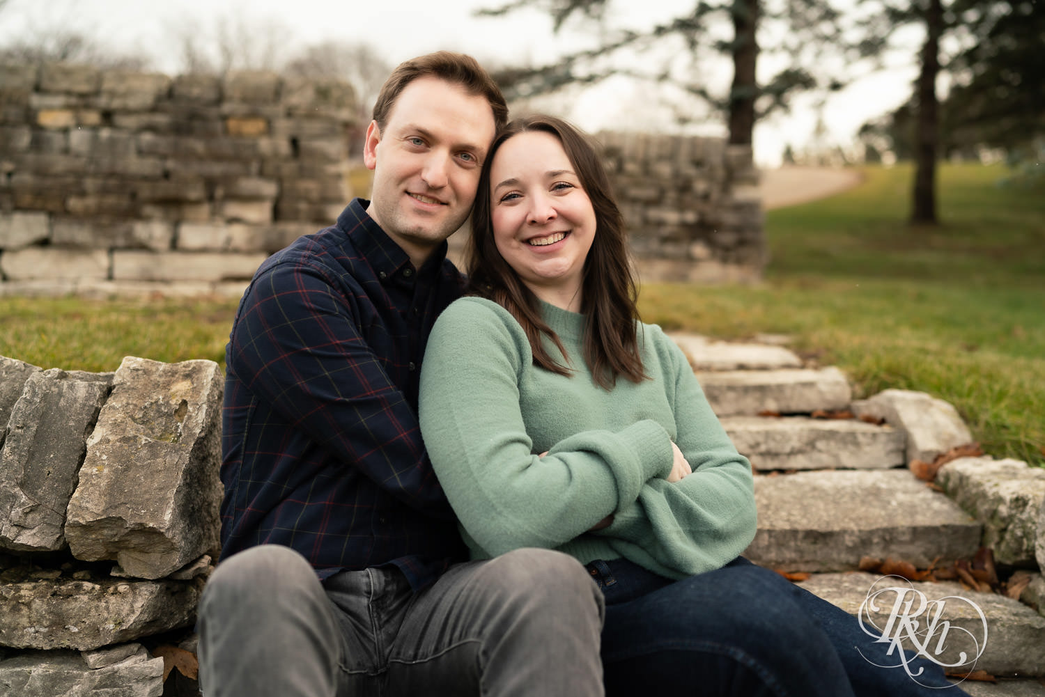 Man and woman smile during winter engagement photography at Minnesota Landscape Arboretum in Chaska, Minnesota.