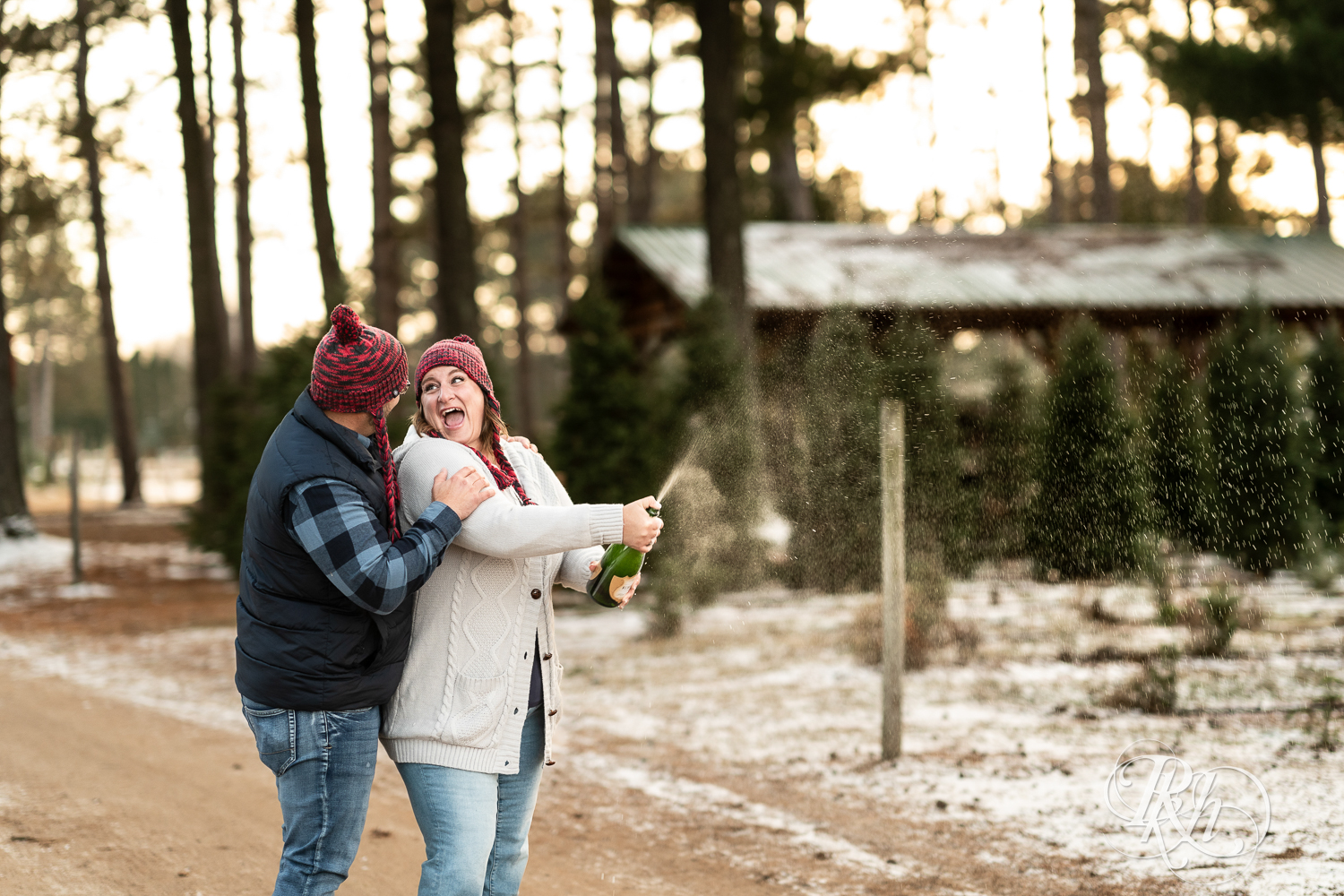 Black man and white woman spray champagne at Hansen Tree Farm in Anoka, Minnesota.