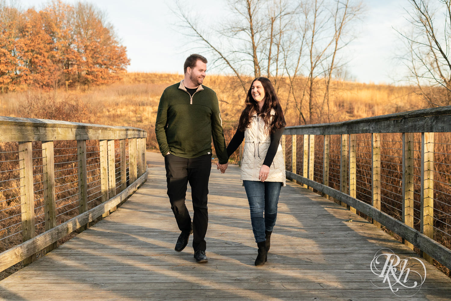Man and woman smile and laugh walking on a bridge at Lebanon Hills in Eagan, Minnesota.