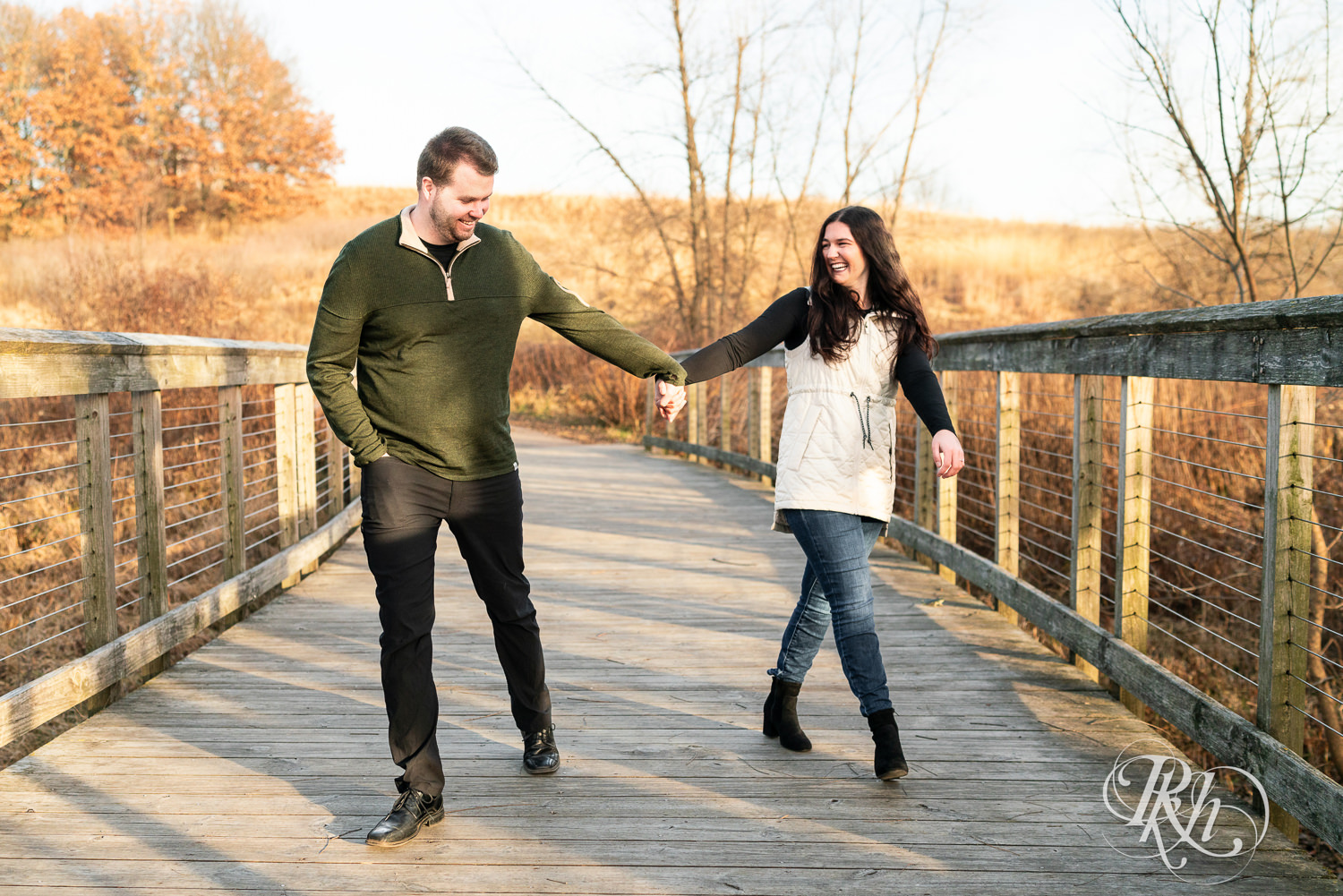 Man and woman smile and laugh walking on a bridge at Lebanon Hills in Eagan, Minnesota.