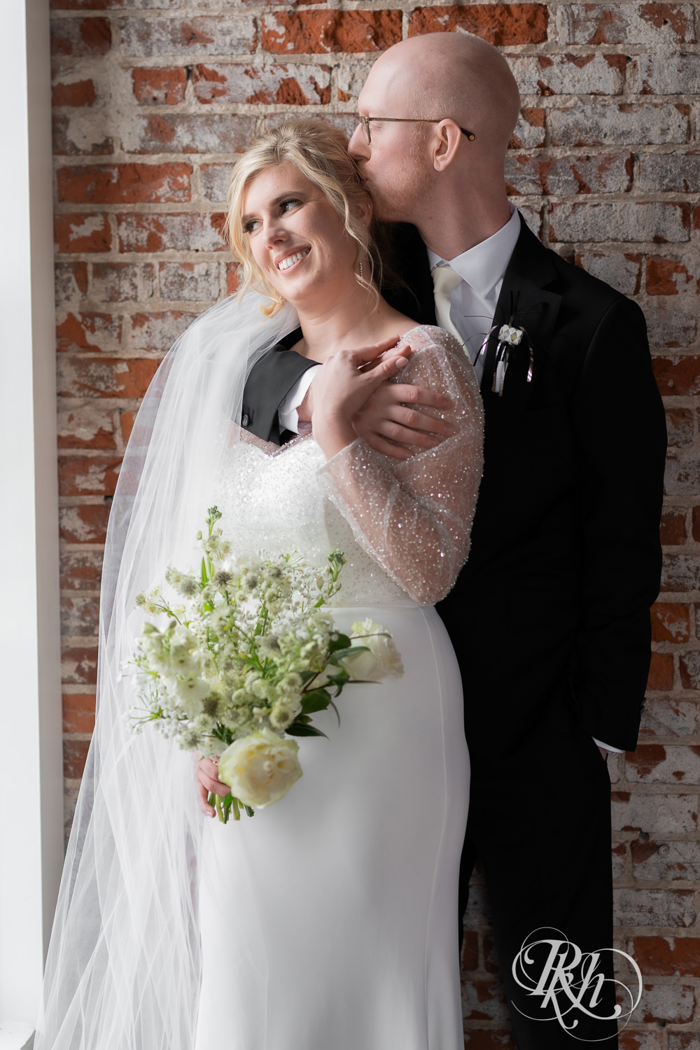 Bride and groom kiss during winter wedding at Gatherings at Station 10 in Saint Paul, Minnesota.