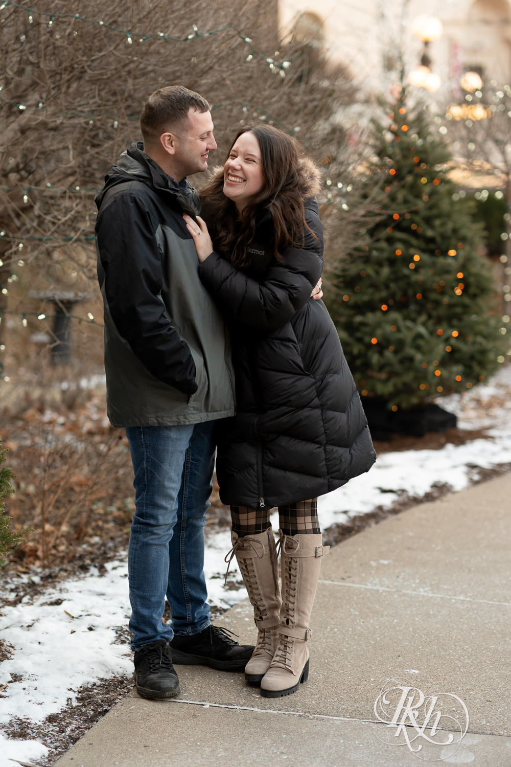 Man and woman in jackets kiss during cold engagement photos at the Saint Paul Hotel in Saint Paul, Minnesota.
