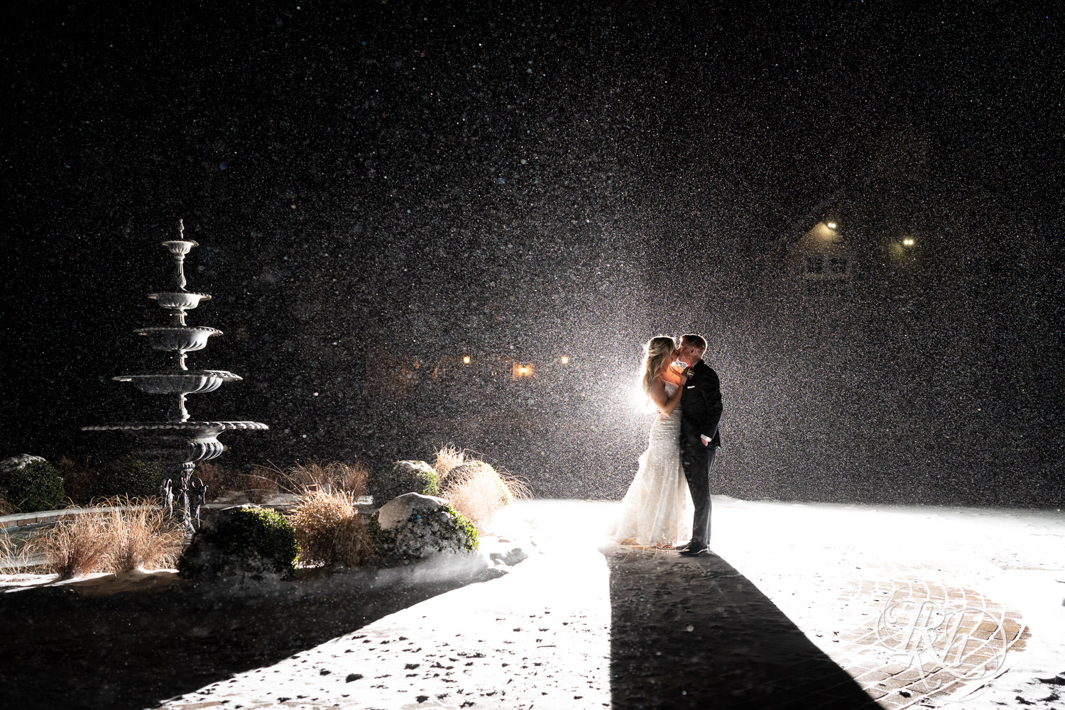 Bride and groom kiss during winter wedding photos in the snow at night at Bavaria Downs in Chaska, Minnesota.