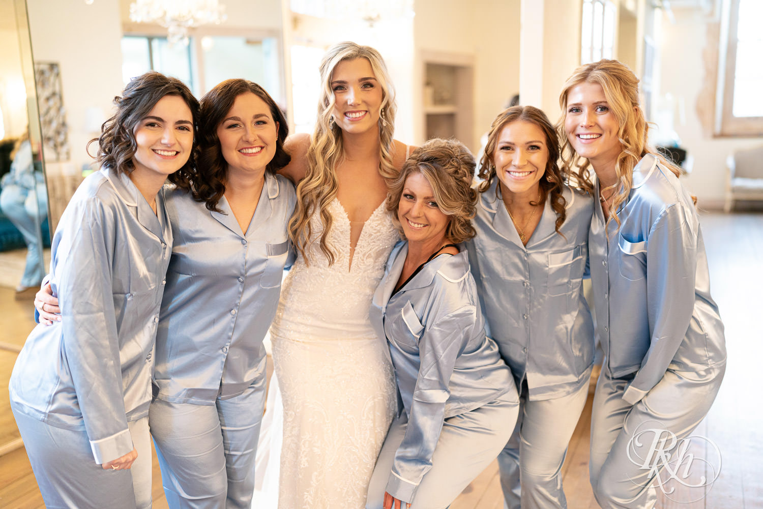 Bridesmaids in blue pajamas hug the bride at Bavaria Downs in Chaska, Minnesota during reveal.