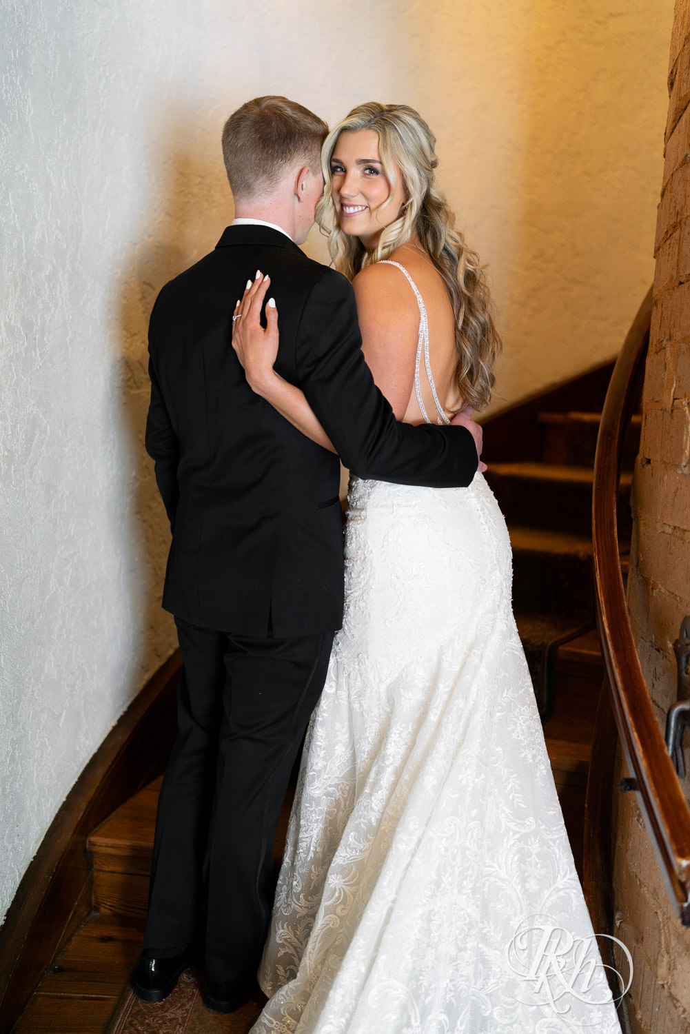 Bride and groom smile on the stairs on wedding day at Bavaria Downs in Chaska, Minnesota.