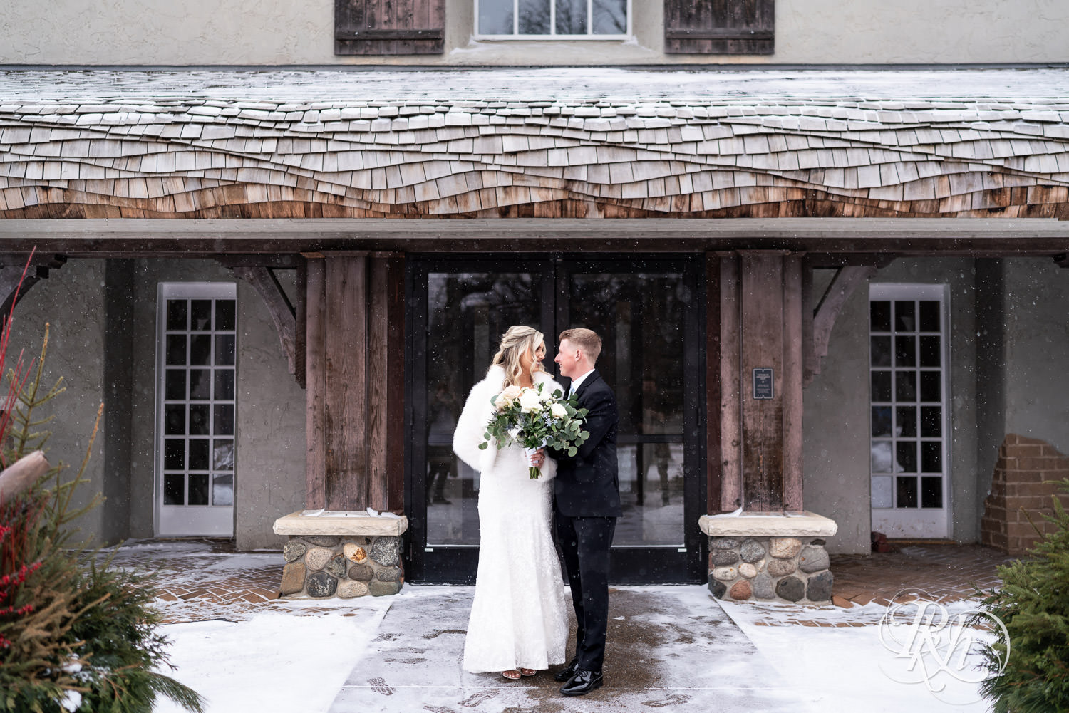 Bride and groom smile in the snow during winter wedding photography at Bavaria Downs in Chaska, Minnesota.