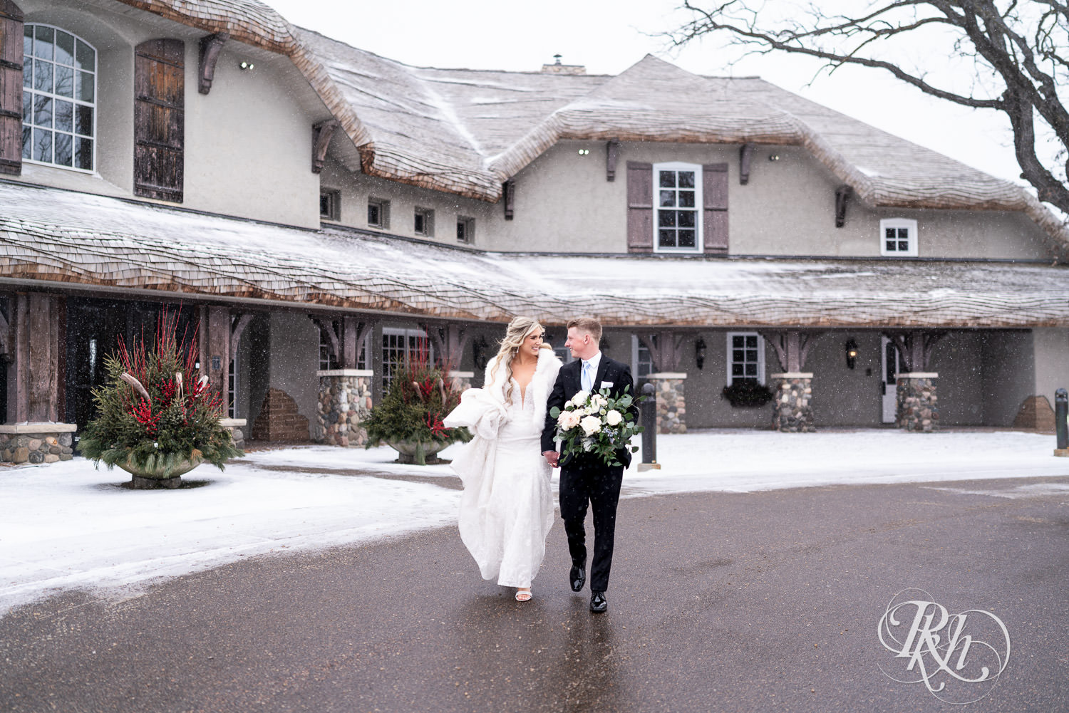 Bride and groom walk in the snow during winter wedding photography at Bavaria Downs in Chaska, Minnesota.