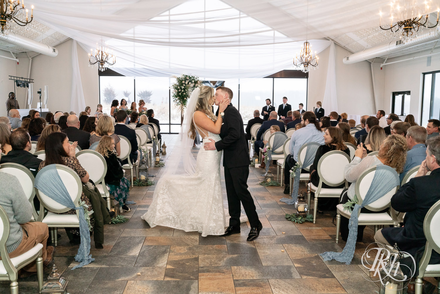 Bride and groom kiss during wedding ceremony at Bavaria Downs in Chaska, Minnesota.