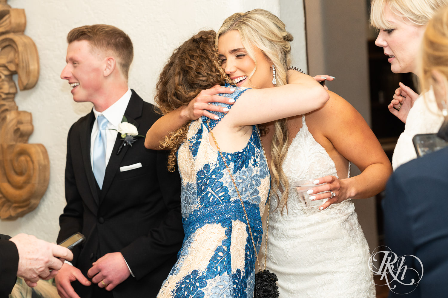 Bride and groom hug guests after wedding ceremony at Bavaria Downs in Chaska, Minnesota.