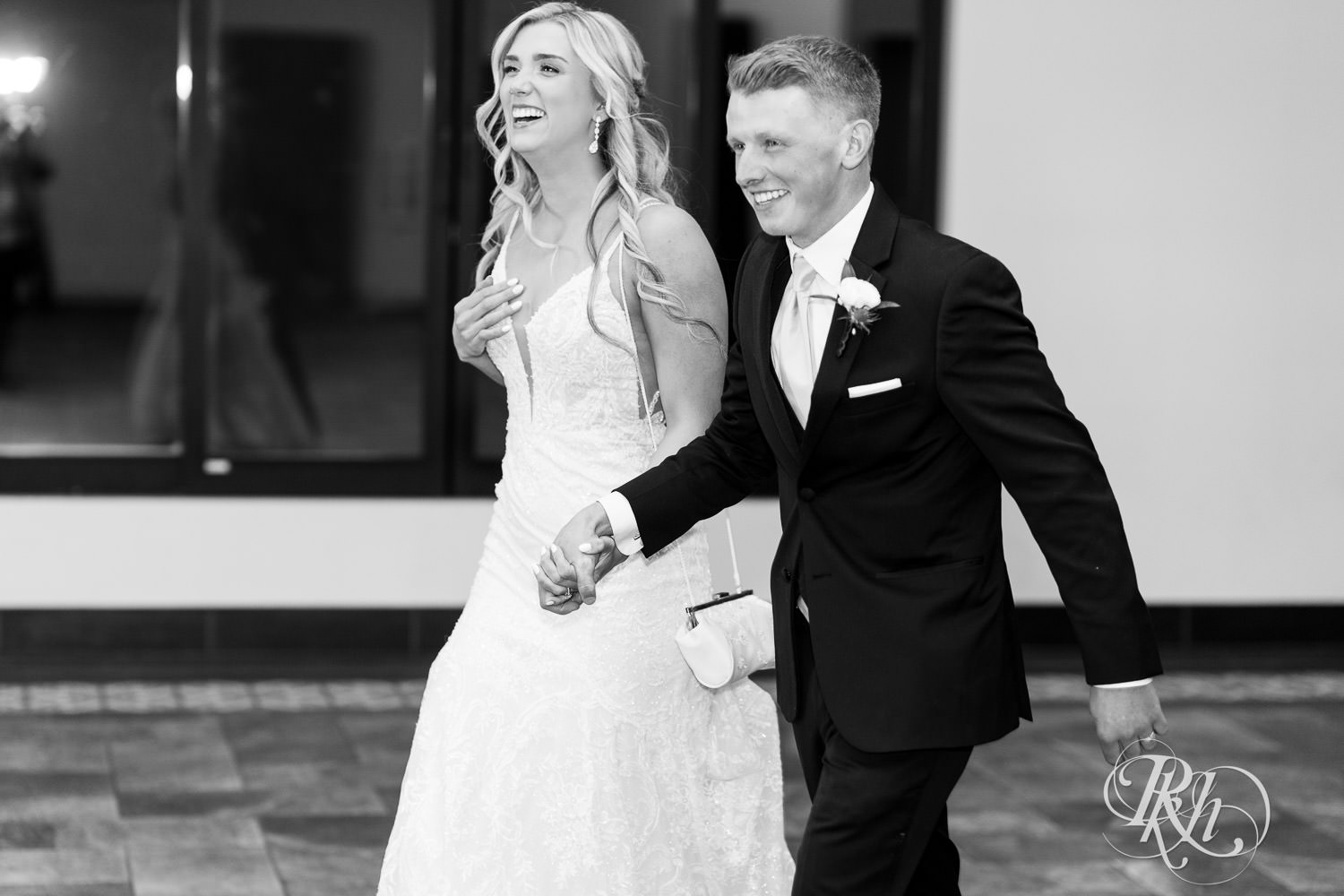 Bride and groom smile during grand entrance at Bavaria Downs in Chaska, Minnesota.