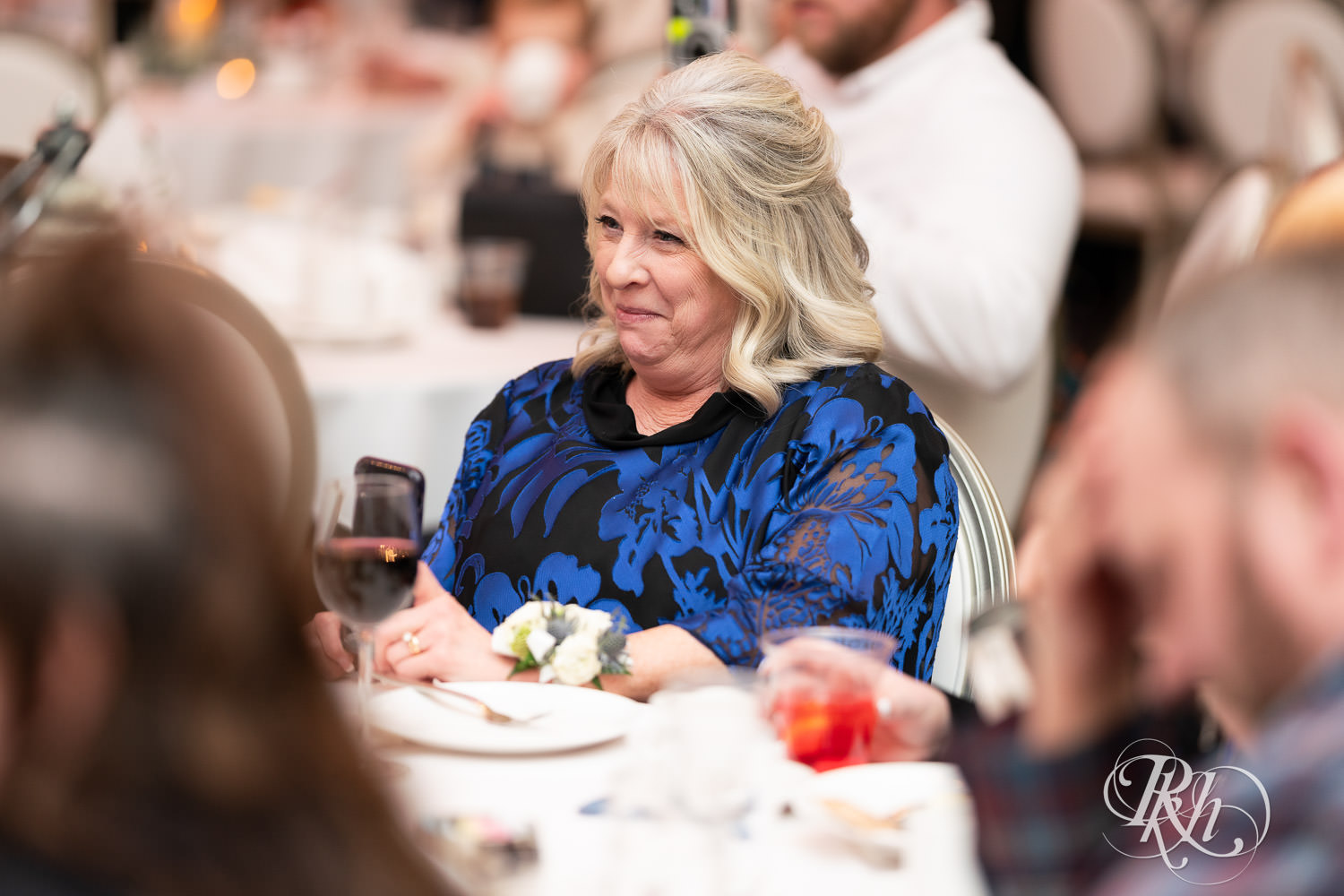 Mother of groom smiles during speeches at wedding reception at Bavaria Downs in Chaska, Minnesota.