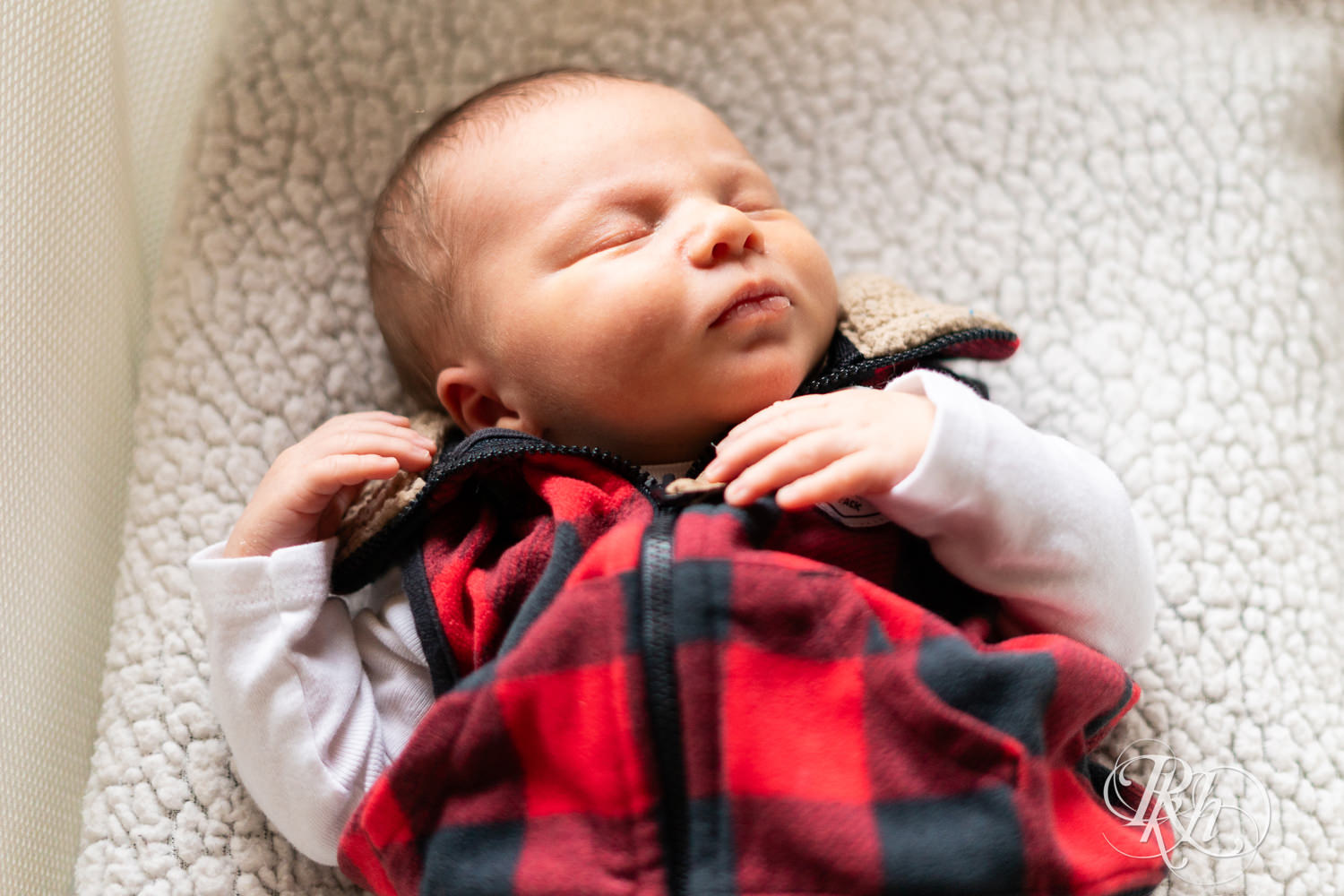 Baby dressed in flannel sleeps during newborn photography session in Ham Lake, Minnesota.
