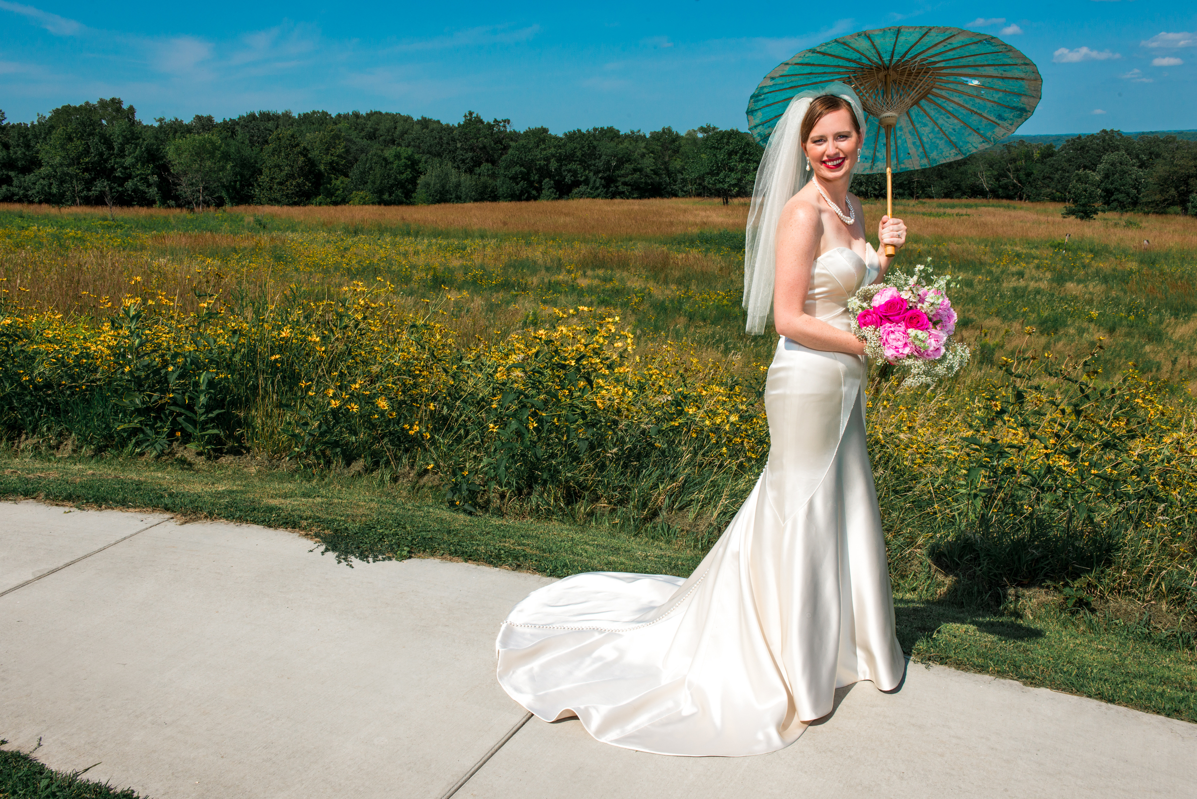 Bride holds parasol at Carpenter Nature Center wedding in Hastings, Minnesota.