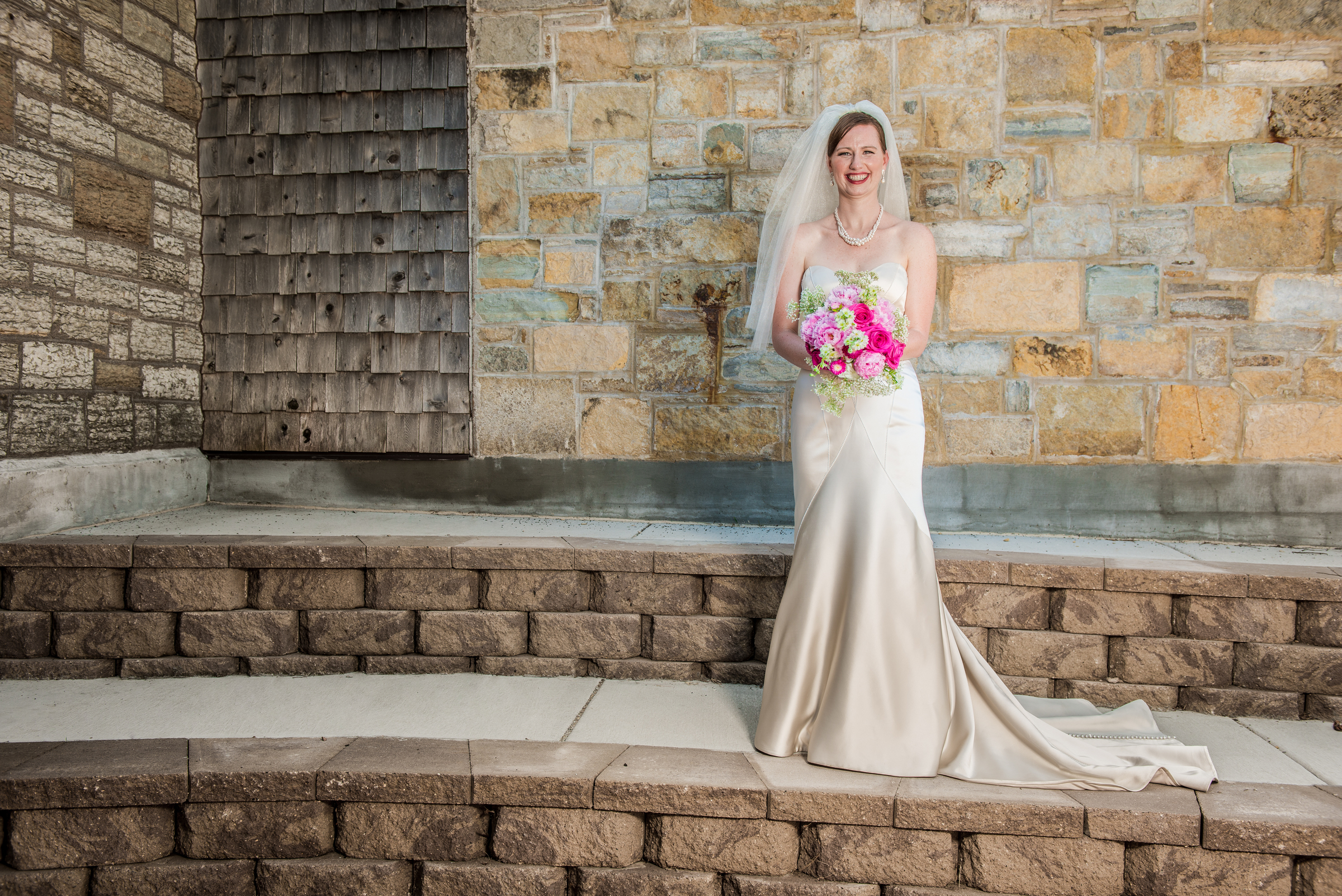 Bride smiles holding flowers at Carpenter Nature Center wedding in Hastings, Minnesota.