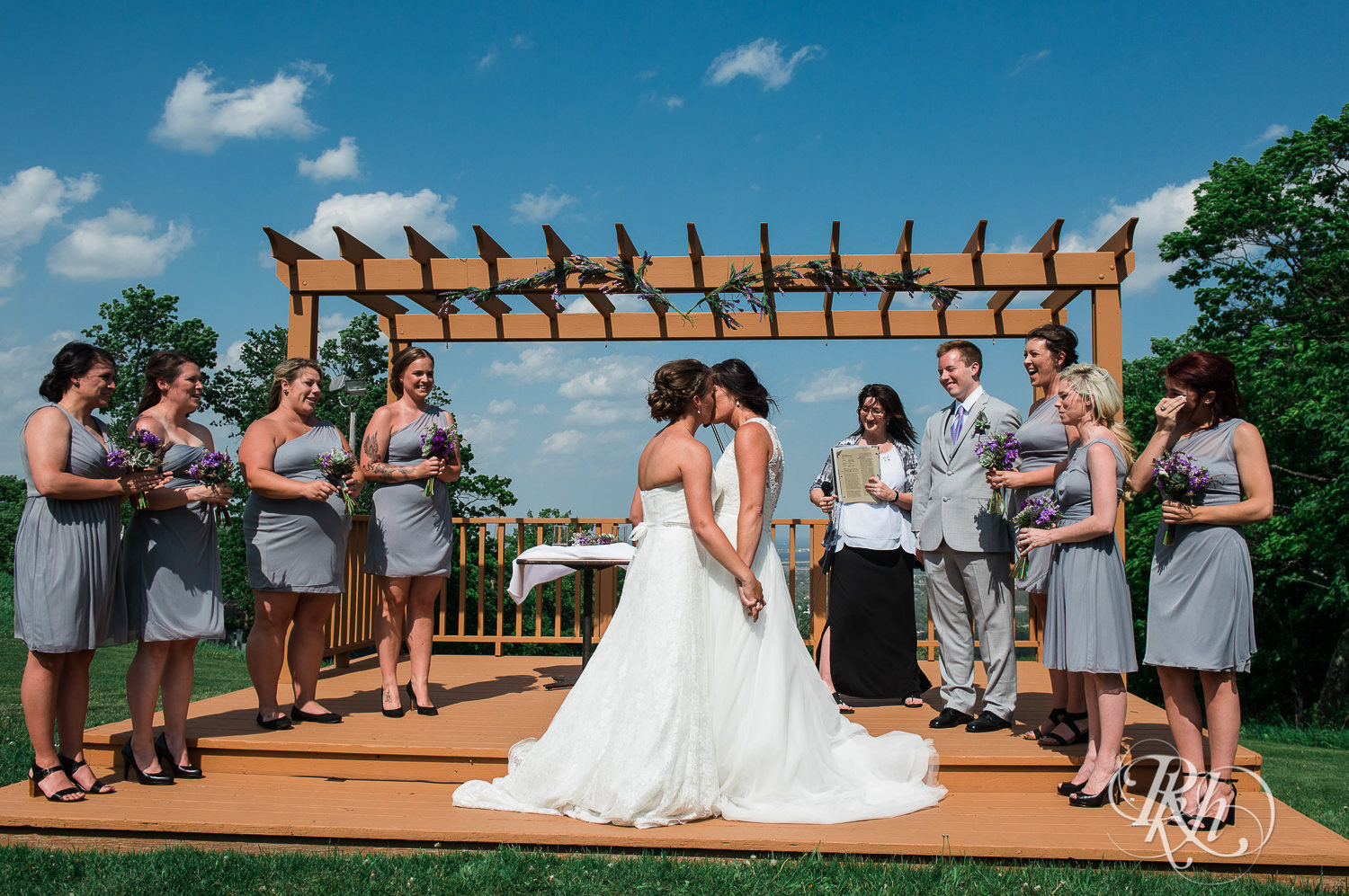 Lesbian brides kiss during outdoor ceremony at Spirit Mountain in Duluth, Minnesota.