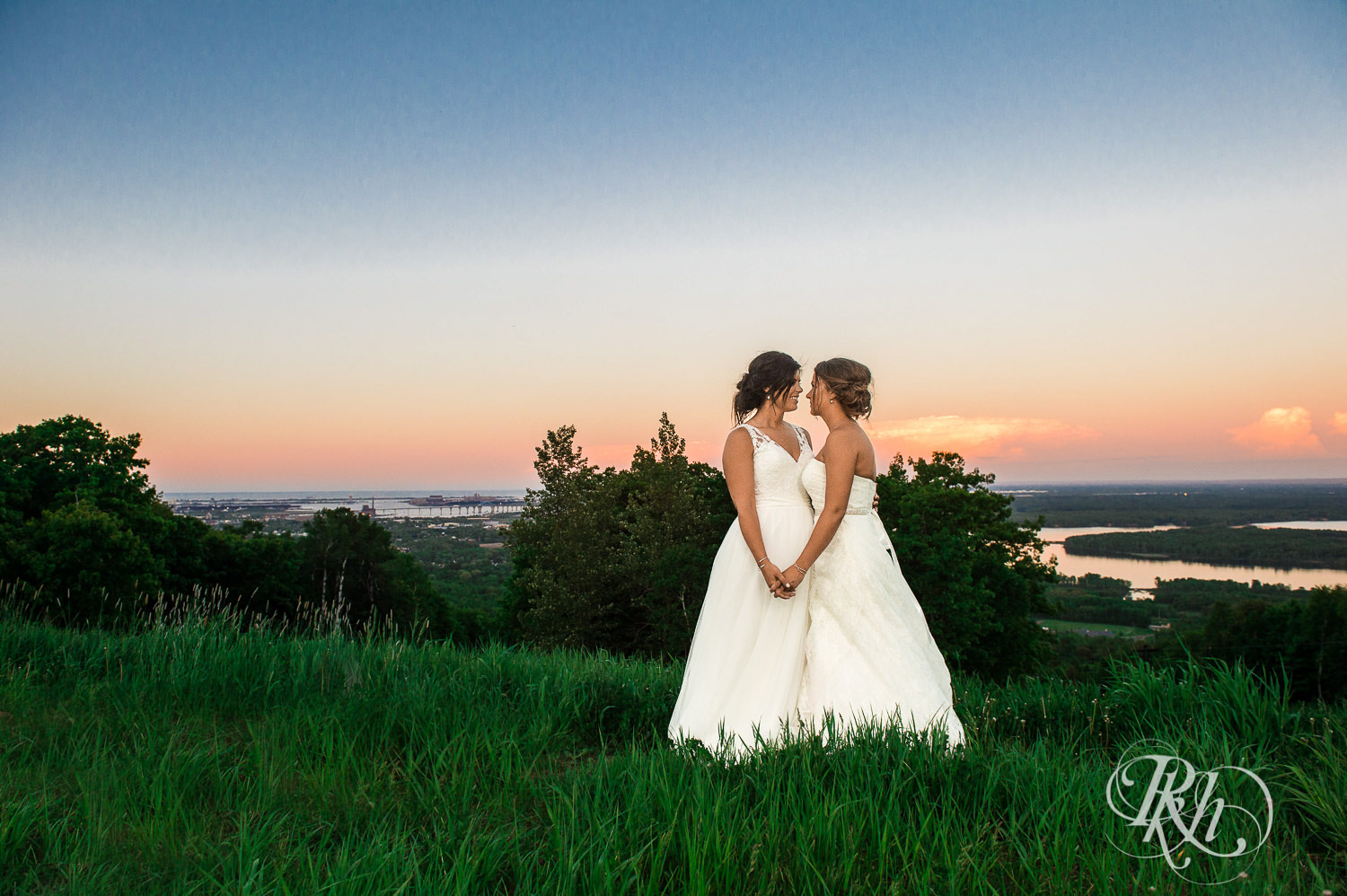 Lesbian brides smile during sunset at Spirit Mountain in Duluth, Minnesota.