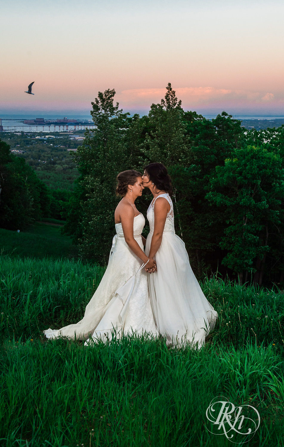 Lesbian brides kiss during sunset at Spirit Mountain in Duluth, Minnesota.