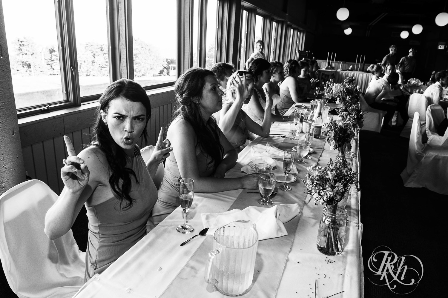 Wedding party laughs at head table.