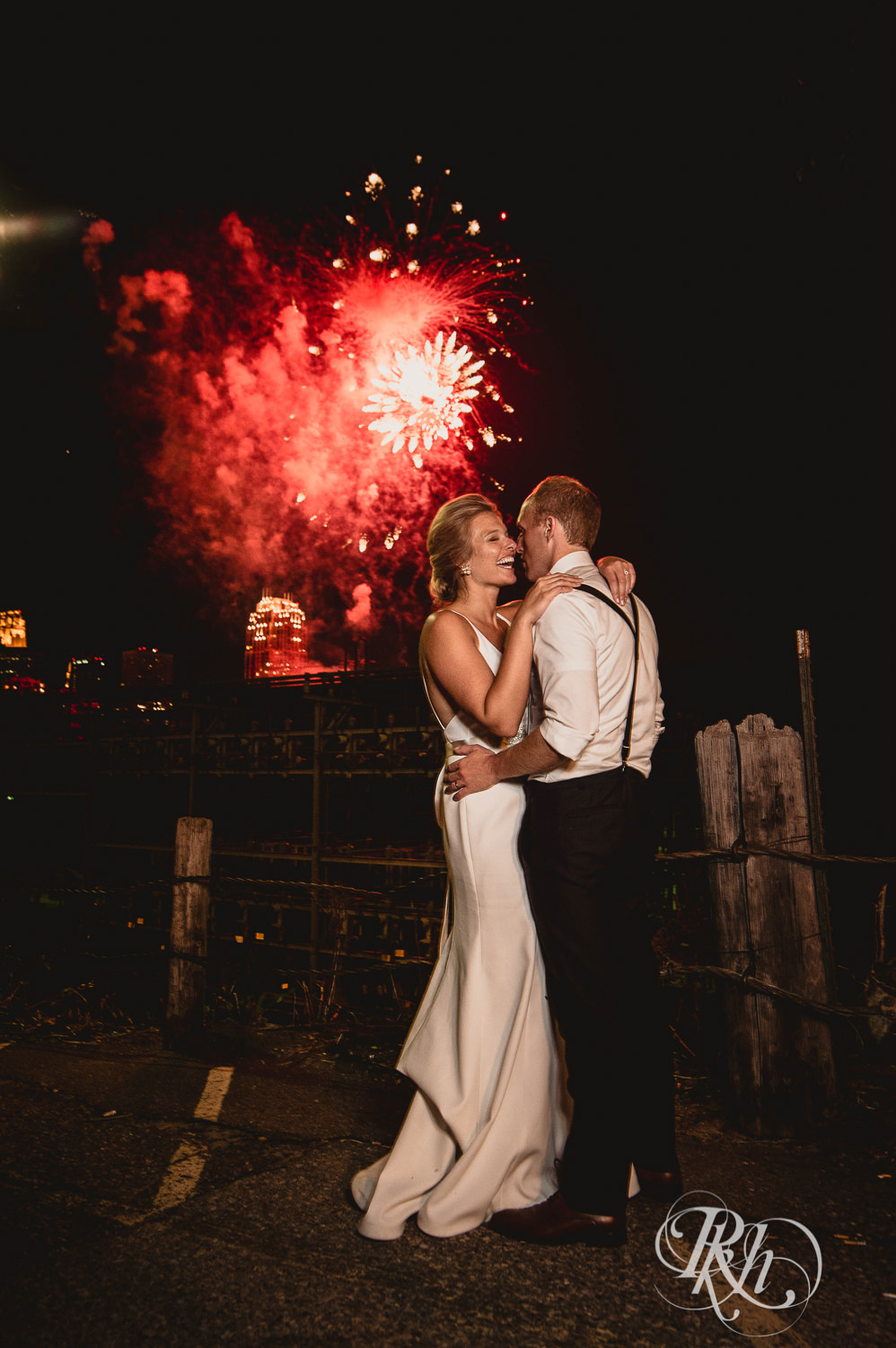Bride and groom kiss in front of fireworks in Minneapolis, Minnesota.