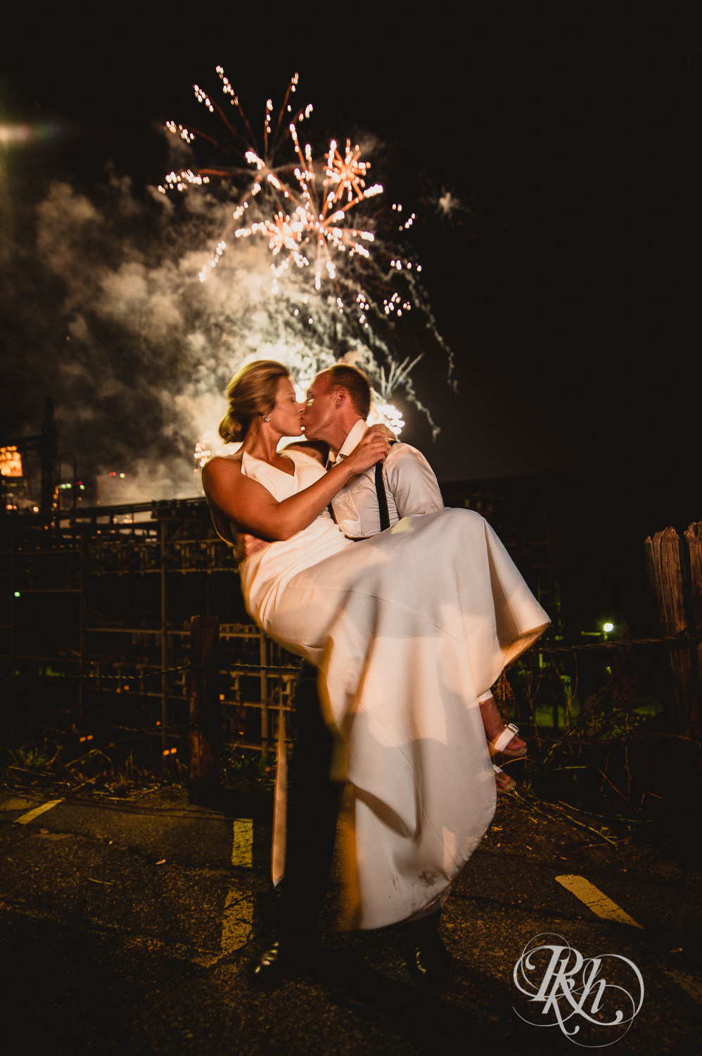 Bride and groom kiss in front of fireworks in Minneapolis, Minnesota.