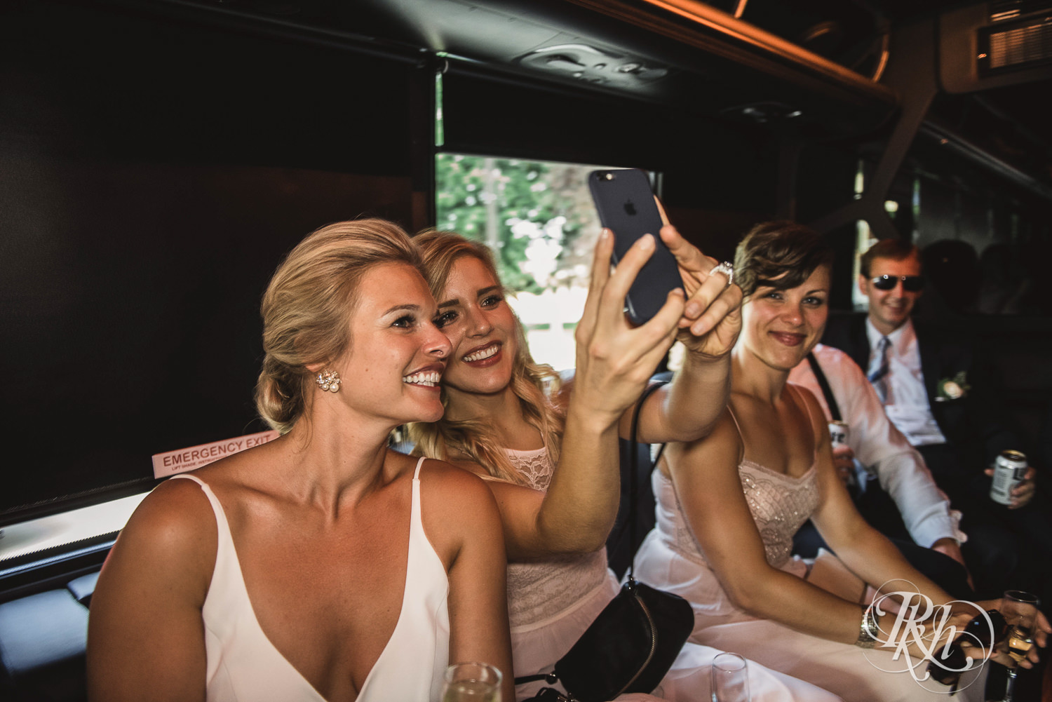 Wedding party takes selfies on party bus in Minneapolis, Minnesota.