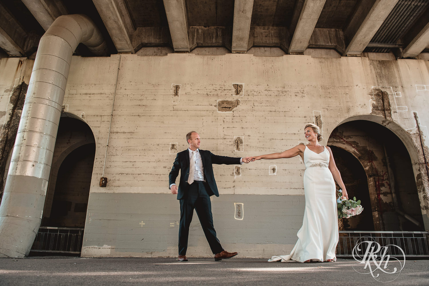 Bride and groom dance under a bridge on their wedding day in Minneapolis, Minnesota.