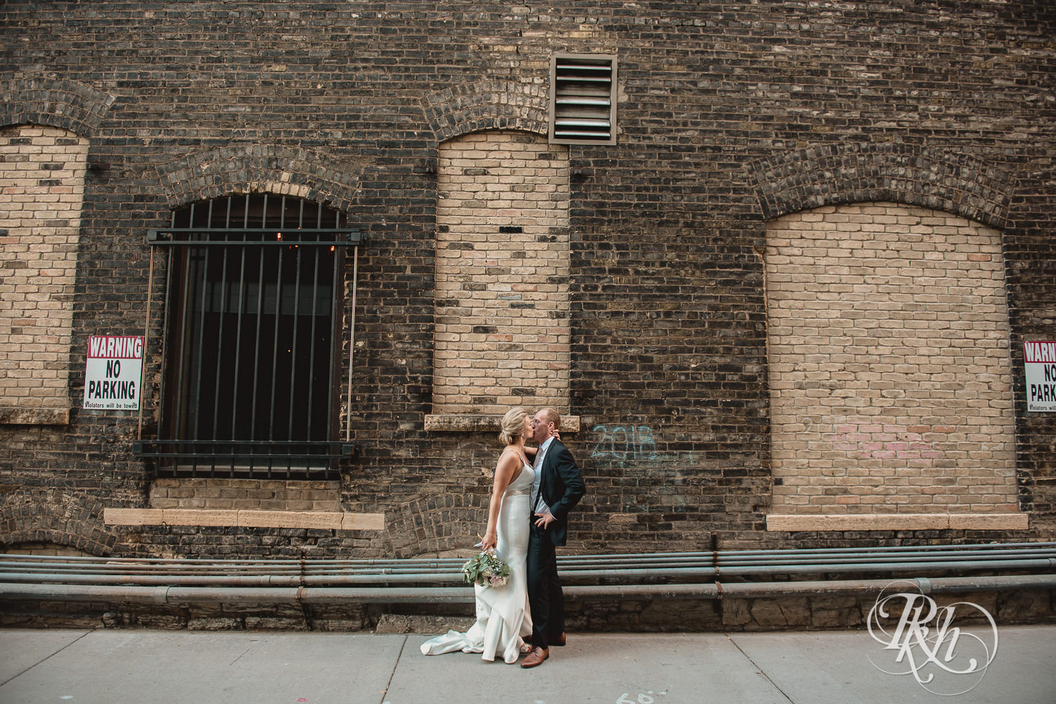 Bride and groom kiss in an alley on their wedding day in Minneapolis, Minnesota.
