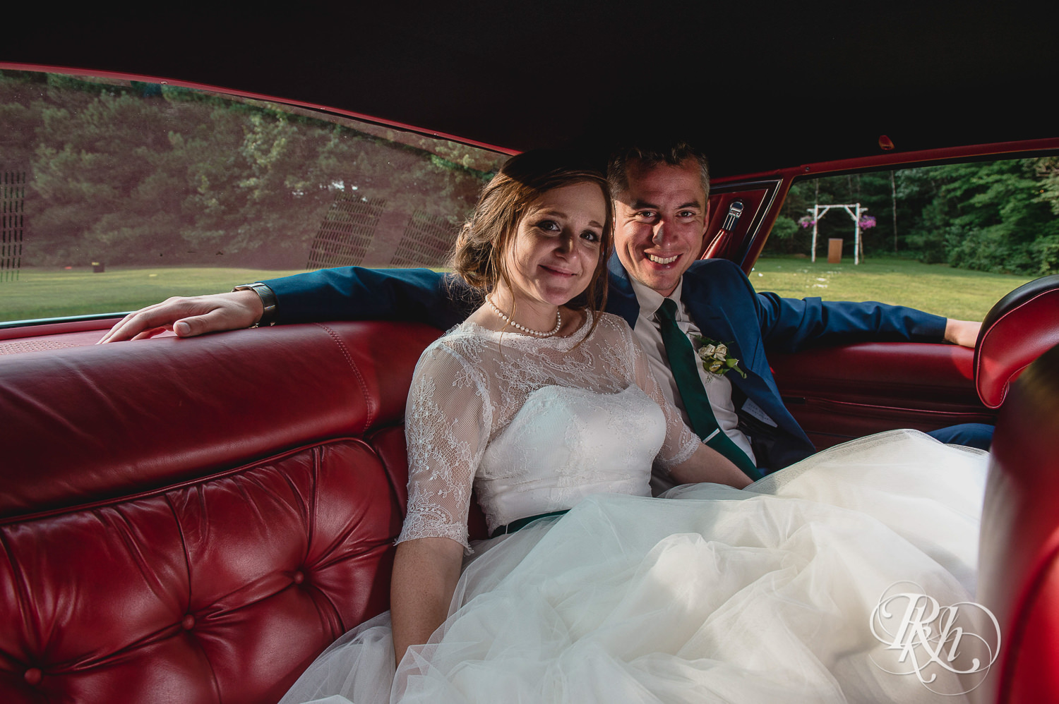 Bride and groom smile in car on wedding day in Elk Mound, Wisconsin.