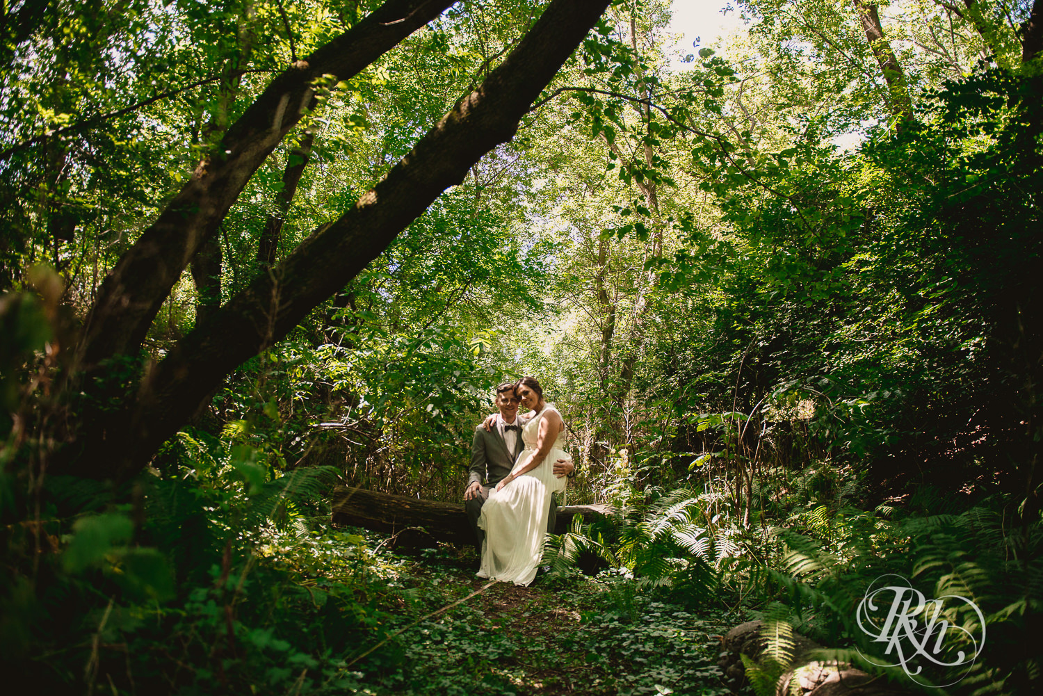 Bride and groom kiss in the woods at Camrose Hill Flower Farm in Stillwater, Minnesota.