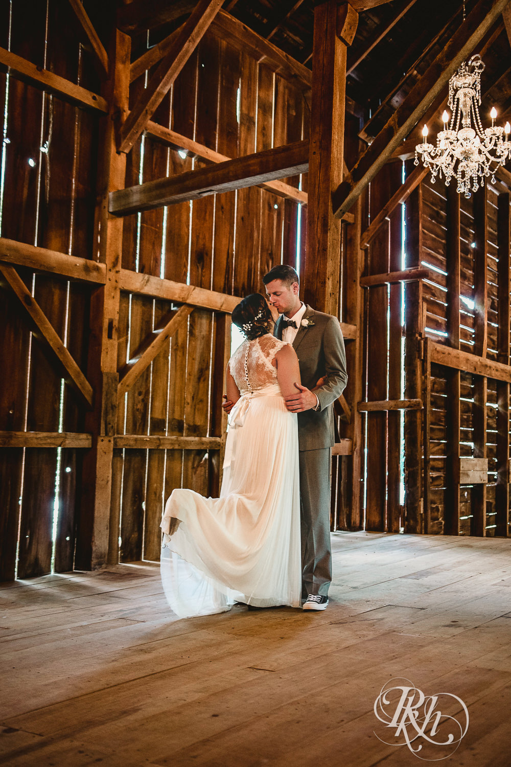 Bride and groom kiss in the barn at Camrose Hill Flower Farm in Stillwater, Minnesota.