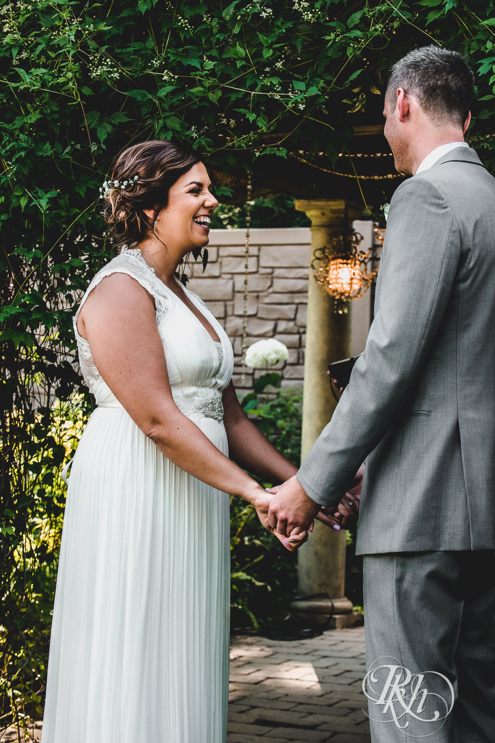Bride and groom smile during wedding ceremony at Camrose Hill Flower Farm in Stillwater, Minnesota.