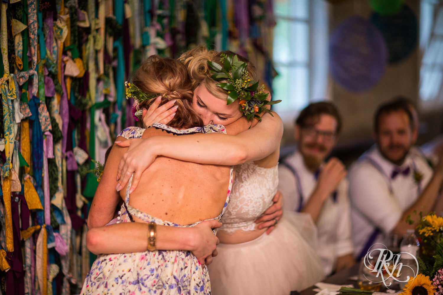 Mom and bride hug during wedding reception at Coops Event Barn in Dodge Center, Minnesota.