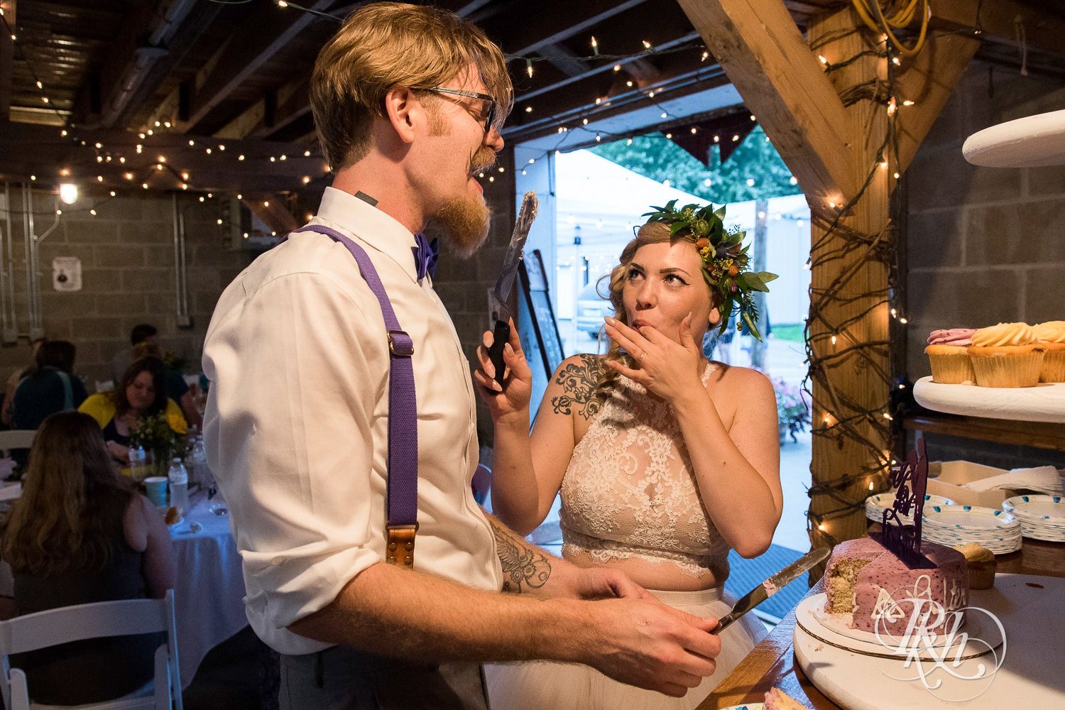 Bride and groom cut cake during wedding reception at Coops Event Barn in Dodge Center, Minnesota.