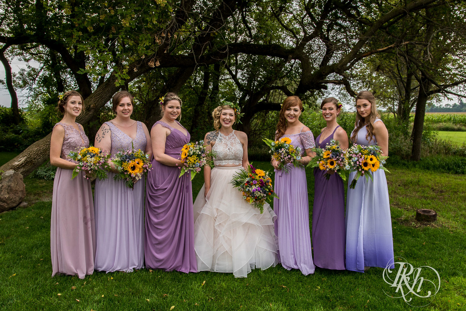 Bride smiles with wedding party before wedding at Coops Event Barn in Dodge Center, Minnesota.