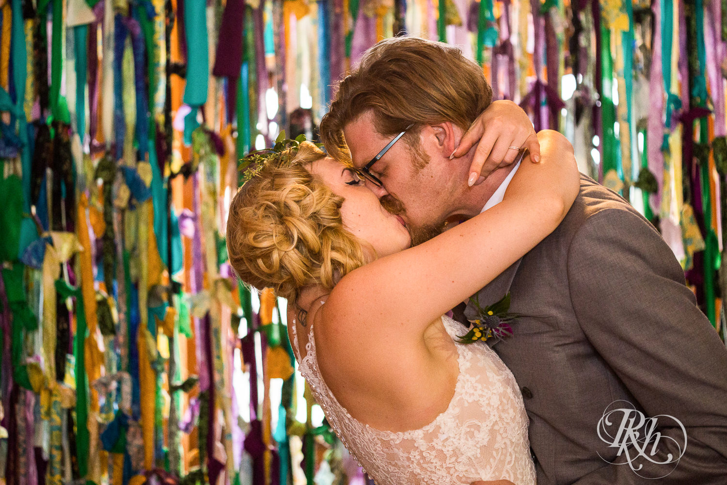 Bride and groom kiss during wedding ceremony at Coops Event Barn in Dodge Center, Minnesota.