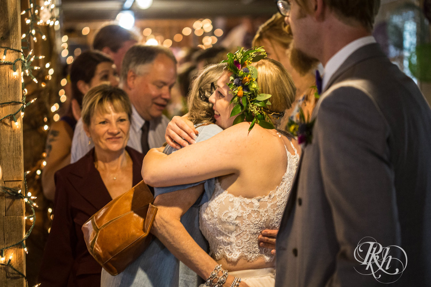 Bride and groom greet and hug guests at Coops Event Barn in Dodge Center, Minnesota.
