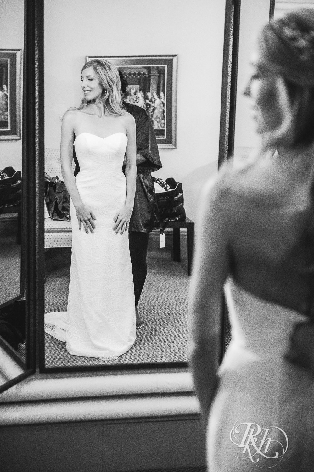 Bride looks at herself in mirror on her wedding day before the ceremony.