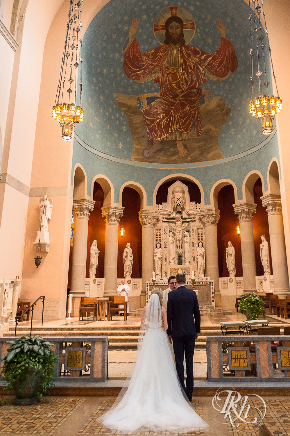 Bride and groom smile during wedding ceremony at St. Thomas Moore Catholic Church in Saint Paul, Minnesota.