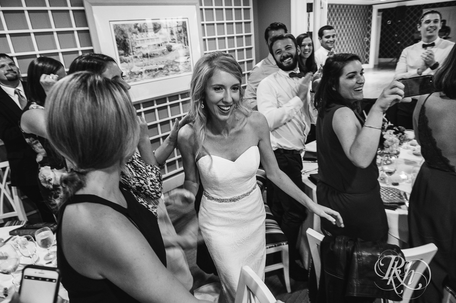 Bride and groom laugh with guests at cocktail hour at White Bear Yacht Club in Dellwood, Minnesota.