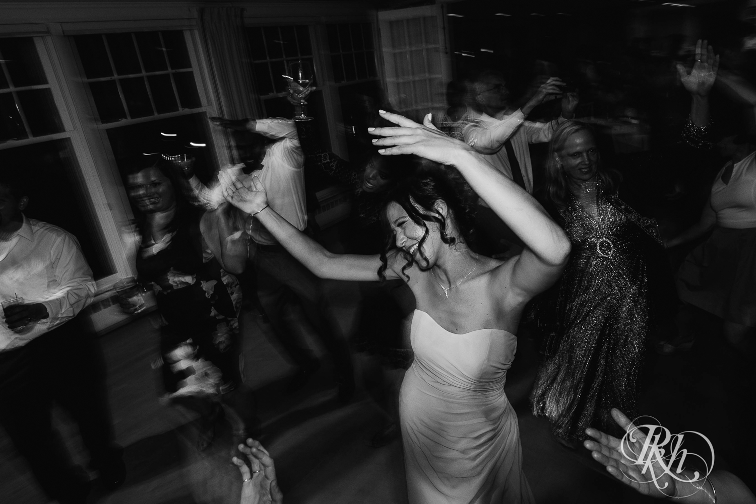 Bride and groom dance with guests during reception at White Bear Yacht Club in Dellwood, Minnesota.