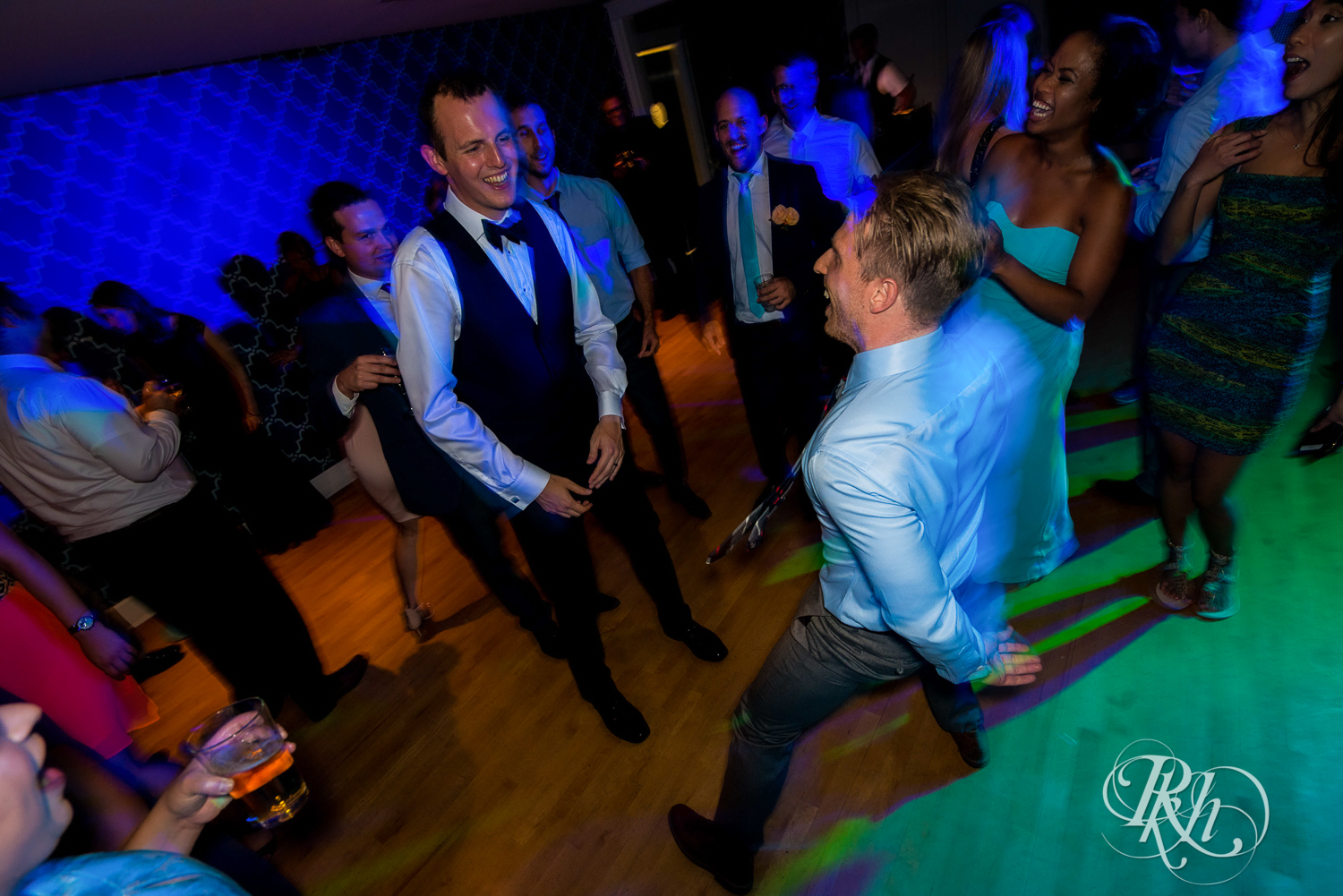 Bride and groom dance with guests during reception at White Bear Yacht Club in Dellwood, Minnesota.
