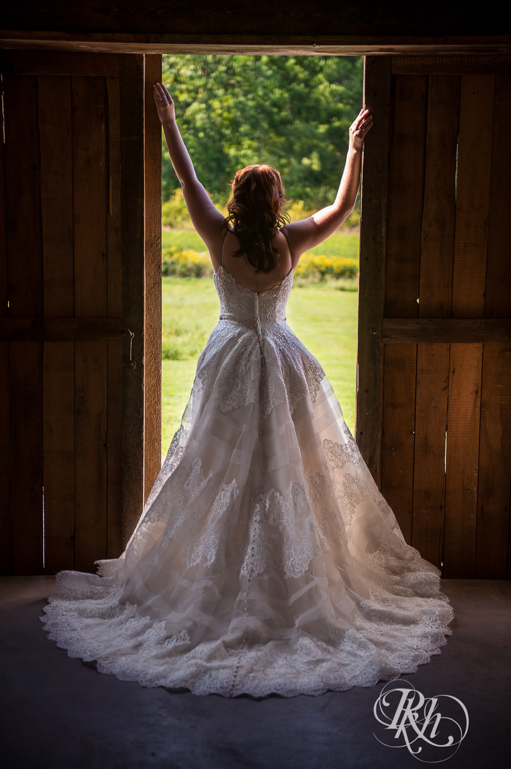 Bride standing between open barn doors during barn wedding at Birch Hill Barn in Glenwood City, Wisconsin.