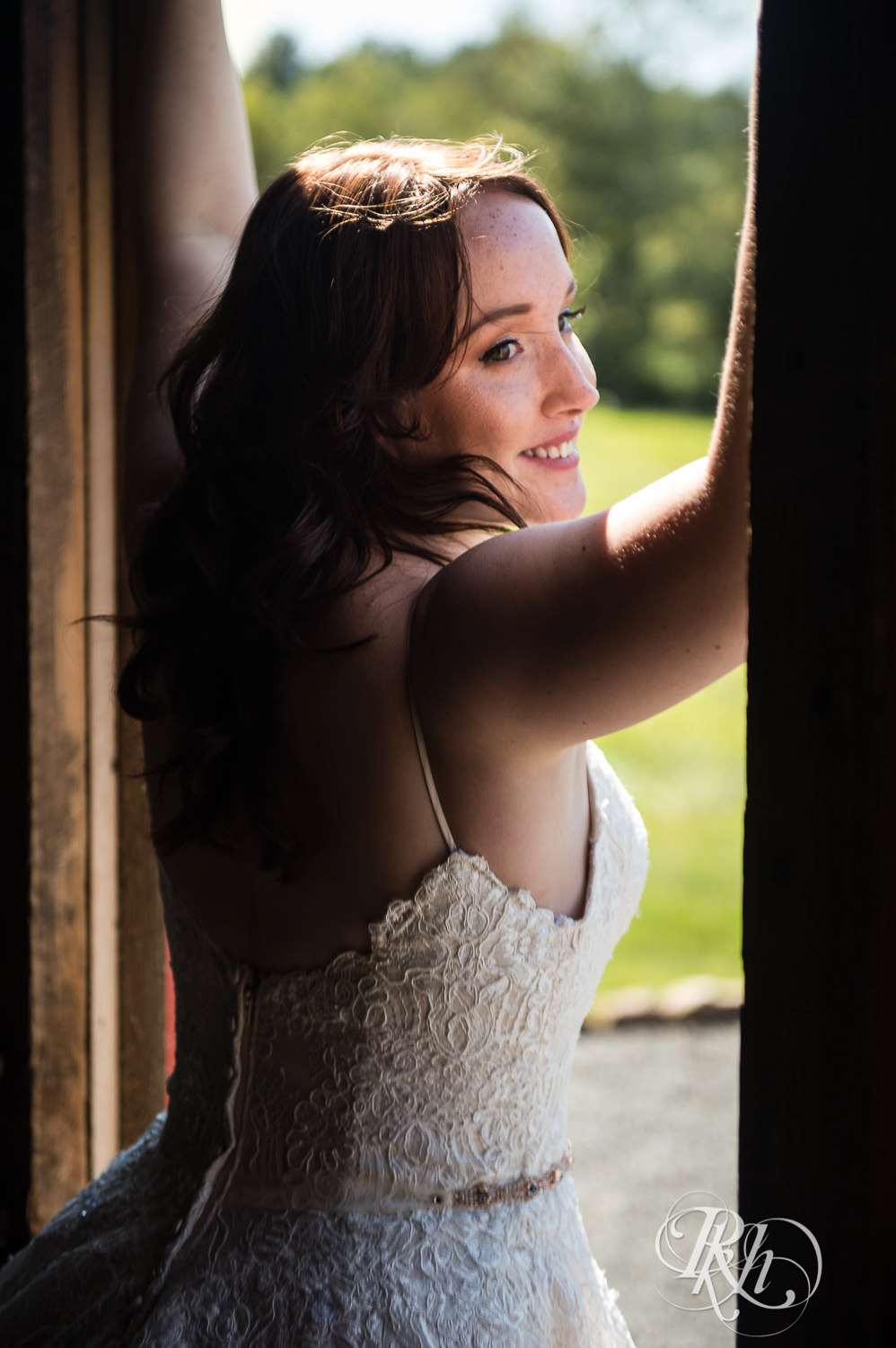 Bride standing between open barn doors during barn wedding at Birch Hill Barn in Glenwood City, Wisconsin.