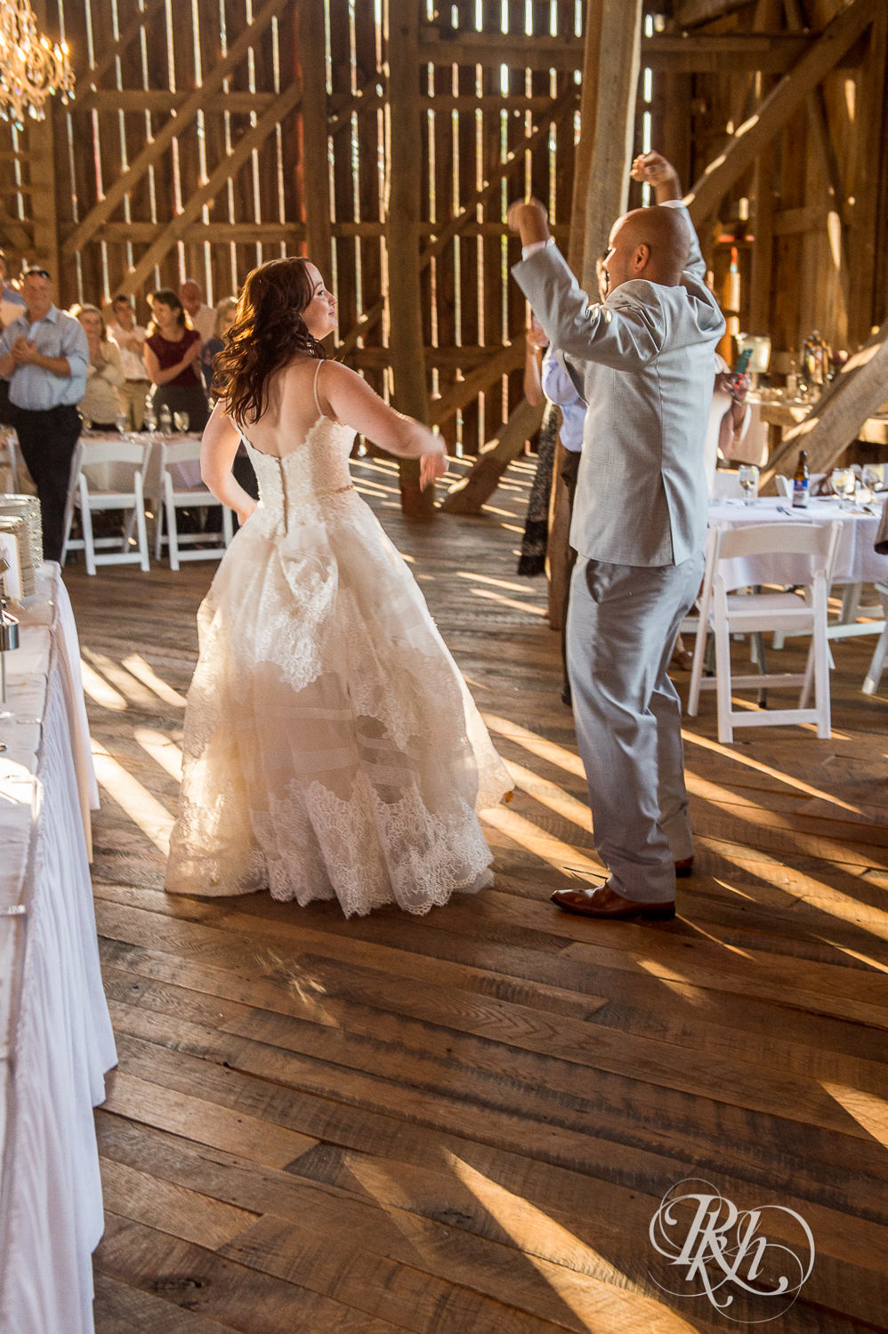 Bride and Asian groom enter wedding reception at Birch Hill Barn in Glenwood City, Wisconsin.