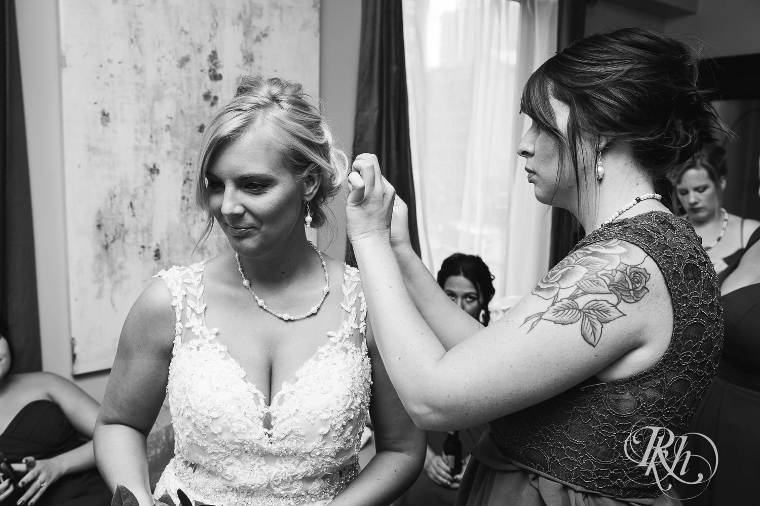Wedding party help bride get dressed in Minneapolis, Minnesota.