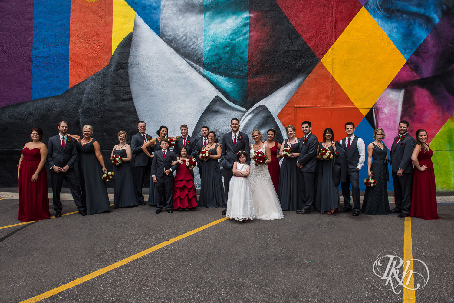 Wedding party smiles in front of the Bob Dylan mural in Minneapolis, Minnesota.