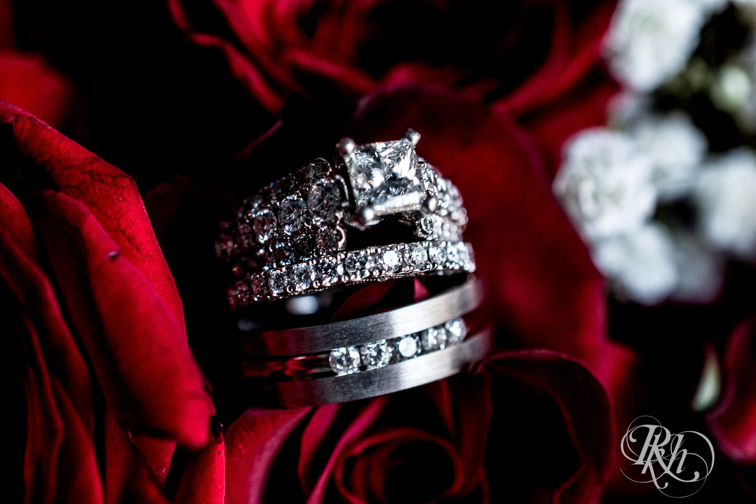 Wedding rings sitting in red roses.